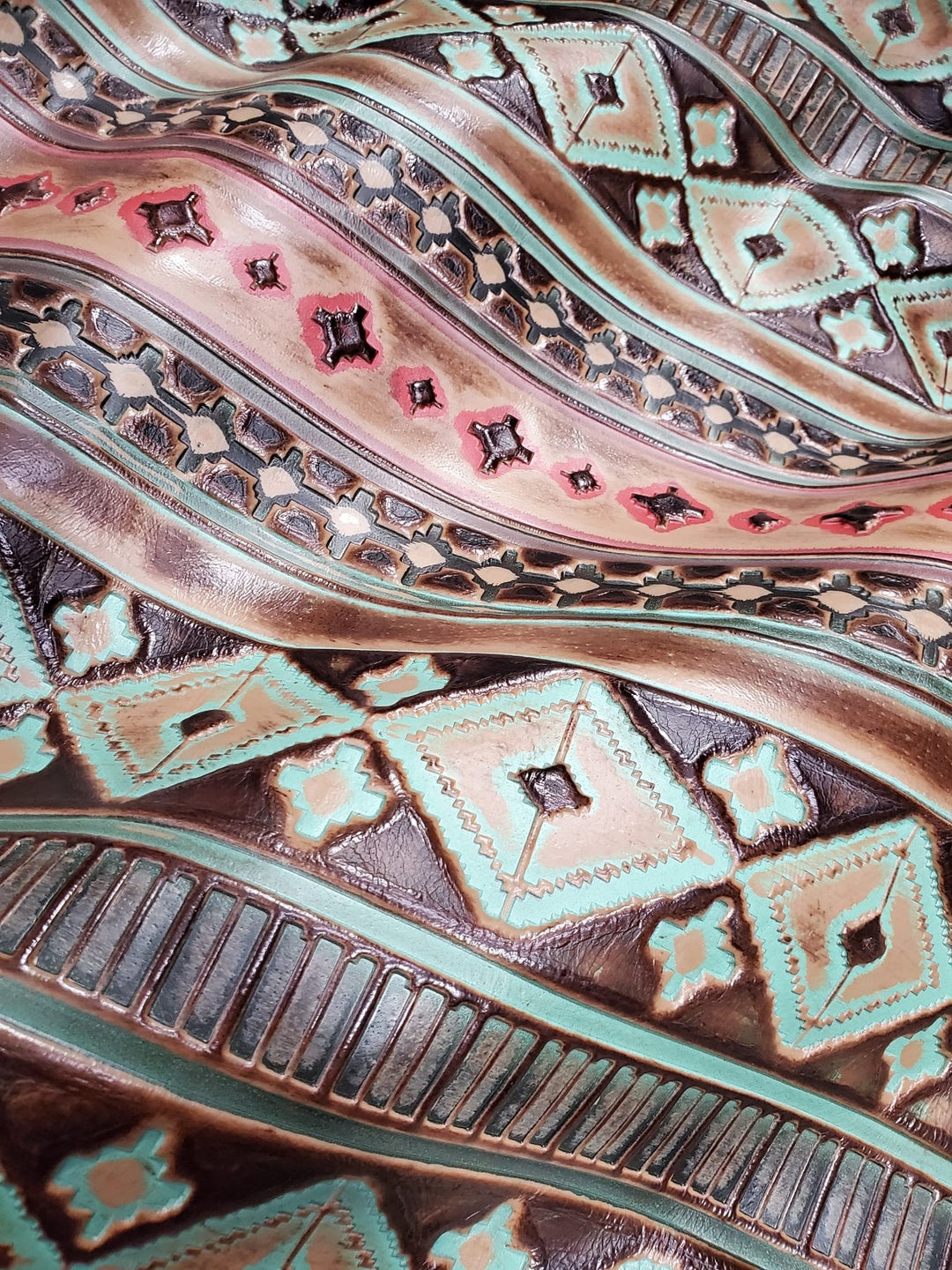 Turquoise leather hat band close-up with embossed geometric motifs and decorative shapes