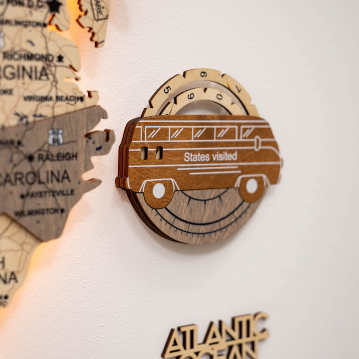 Close-up of wooden car-shaped USA travel tracker with “States visited” text.