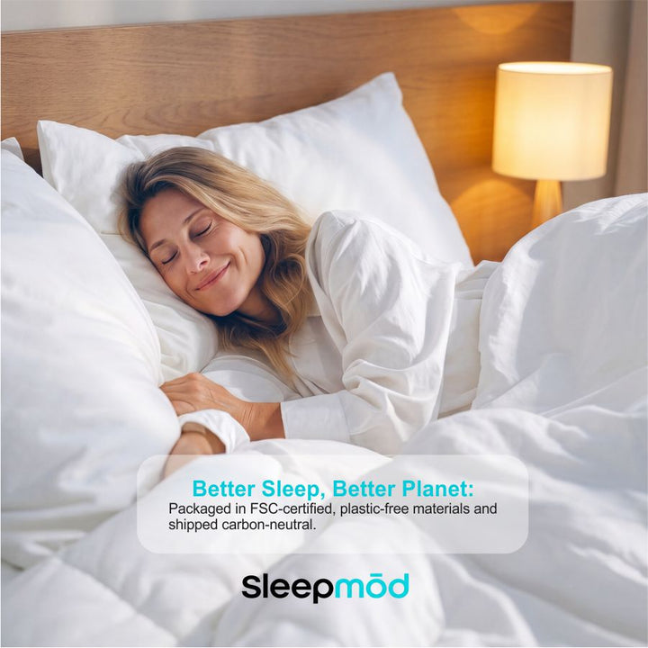 White comforter and pillow shams on a bed with a sleeping person