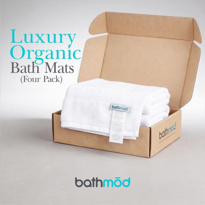 White bath mats in open brown box, four-pack presentation