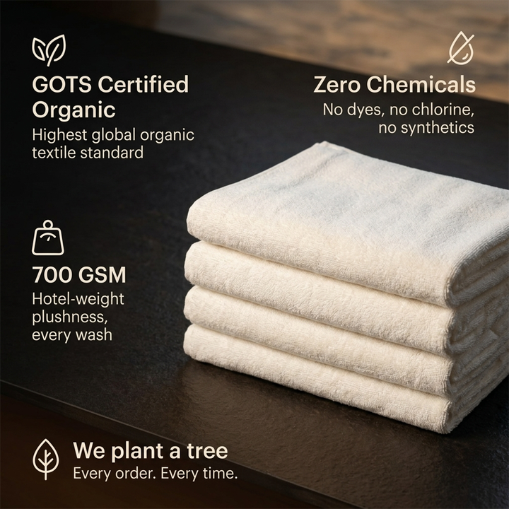Folded white bath towels stacked on a tray, showing plush texture and stitched hems.