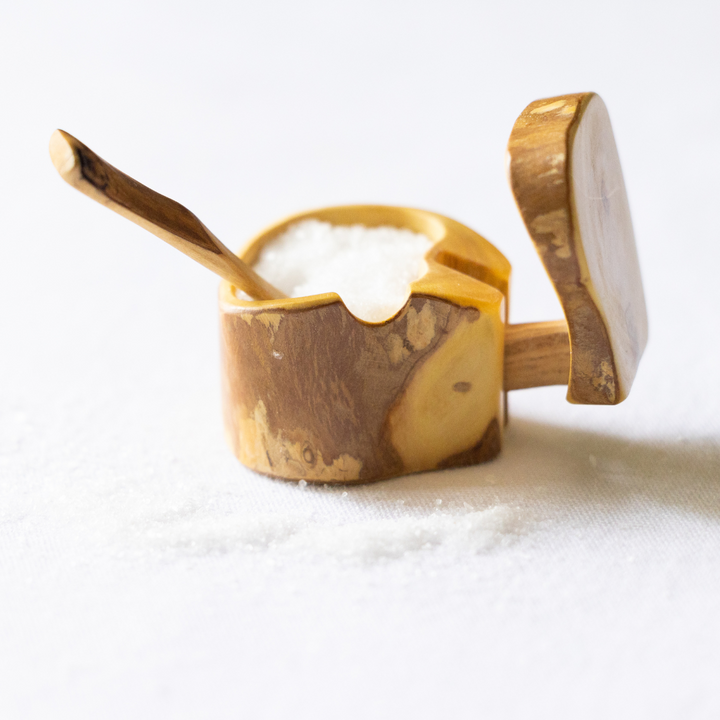 Mini wooden salt box with hinged lid and wooden spoon, filled with white salt