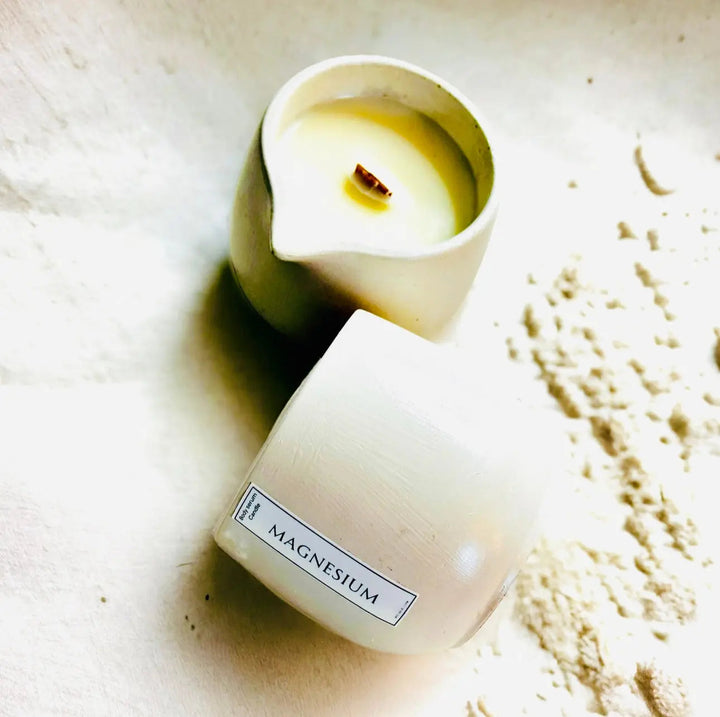 Magnesium candle in a short jar with open wax top and scattered wax flakes