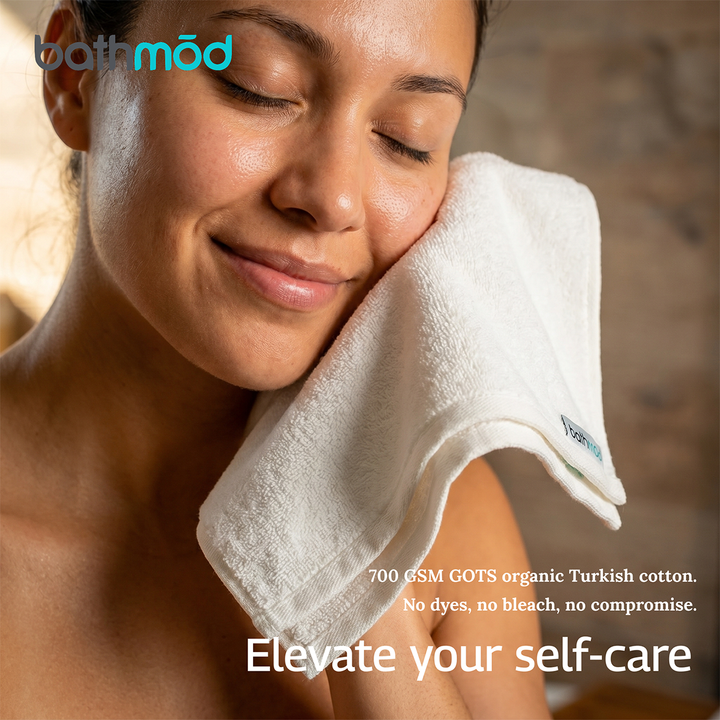 White plush bath towel draped over a shoulder, close-up on textured fabric