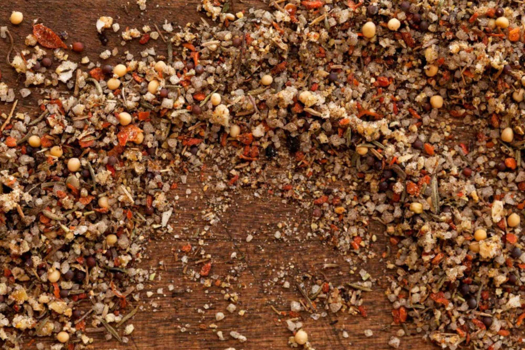 Coarse seasoning blend with herbs and seeds scattered on a wood board