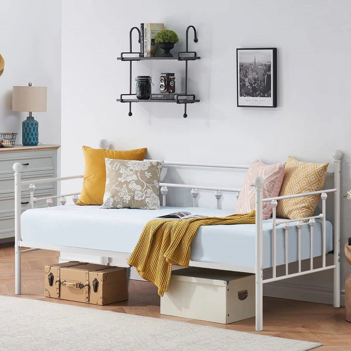 White metal twin daybed frame with curvy finials and slatted mattress support