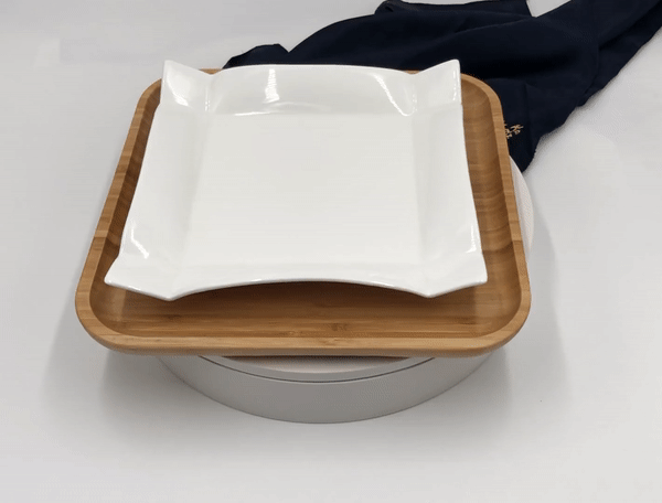 Square white porcelain dinner plate on bamboo serving tray