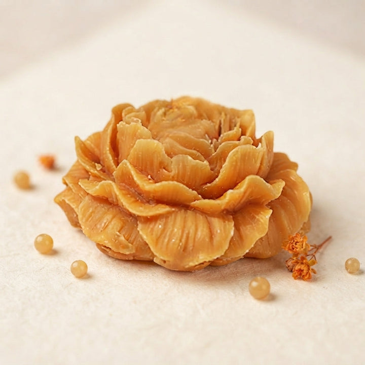 Orange wax flower freshener with layered petals on a clean surface