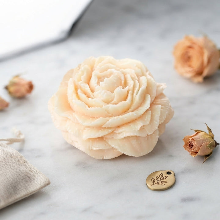 Light cream wax flower freshener with layered petals on a marble surface