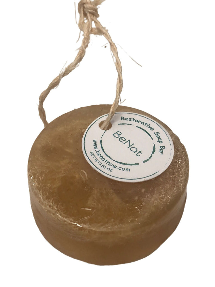 Round brown BeNat restorative soap bar with hanging rope, label facing up