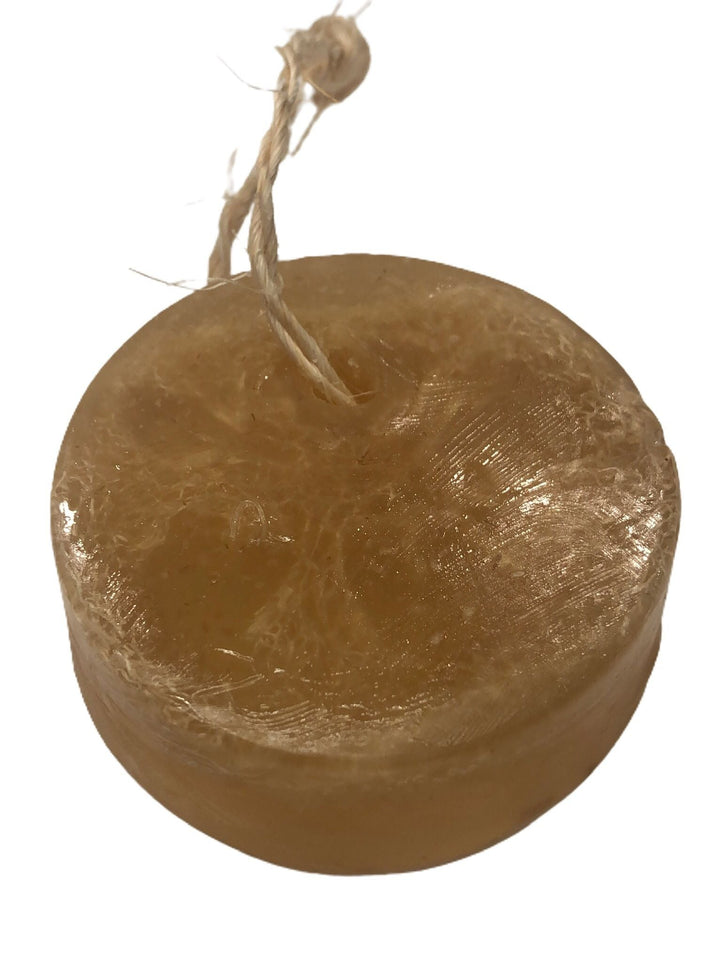 Round brown soap bar with braided cotton rope, close-up view