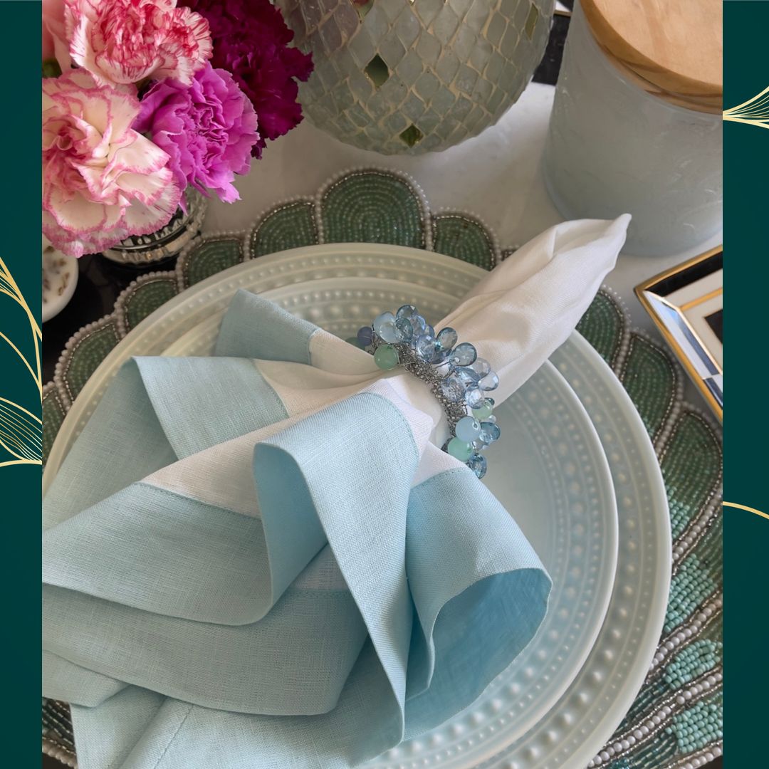 Mint linen napkins with light green borders, folded for a table setting