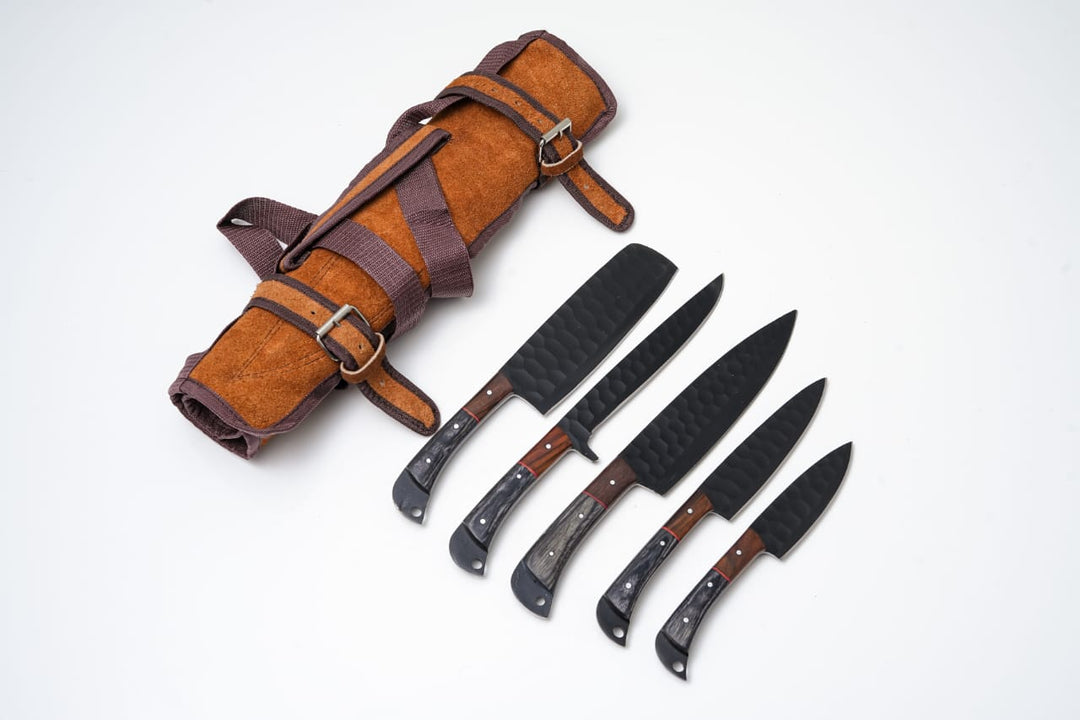 5-piece kitchen knife set with black blades and handles, stored in rolled leather sheath