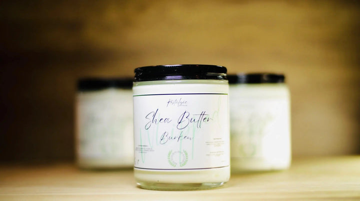 Whipped shea body butter jar with black lid in front of another white tub