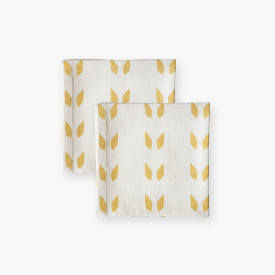 Set of 2 white linen napkins with mustard leaf print, folded