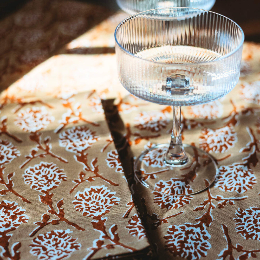 Close-up linen runner with white floral medallion hand print in chai brown