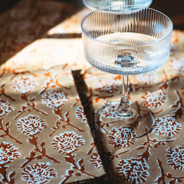 Close-up linen runner with white floral medallion hand print in chai brown