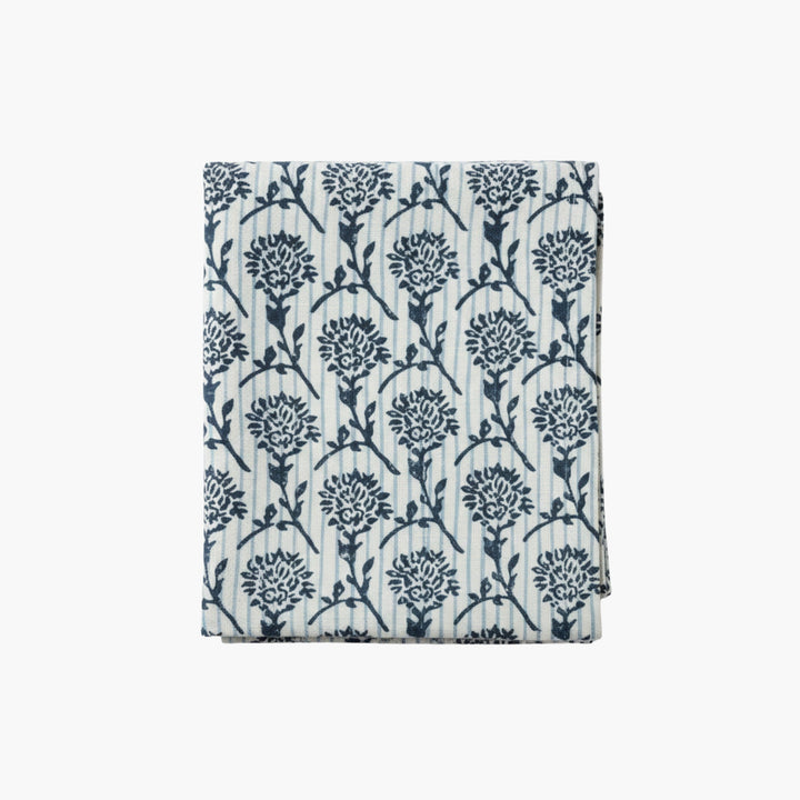 Linen runner with hand-printed blue botanical motif on light background