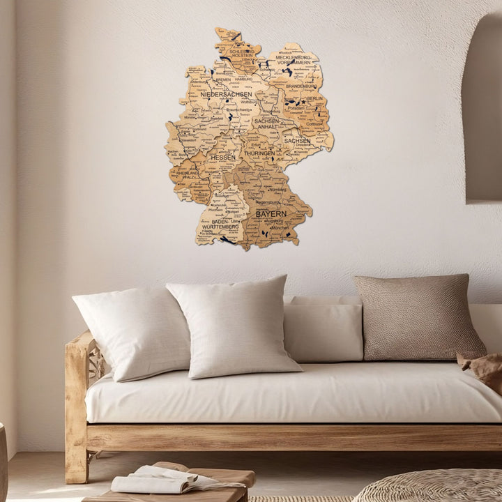 3D wooden Germany wall map mounted above a sofa in a living room