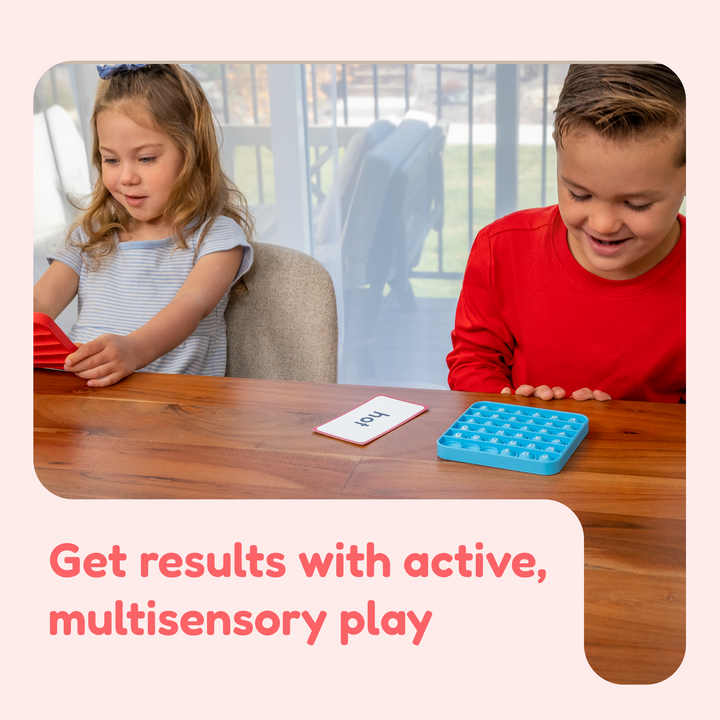Kids playing with pop-it letter mats and word cards at a table