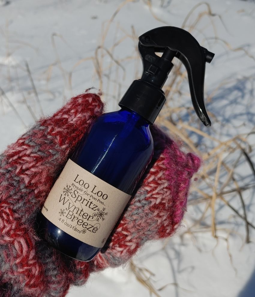 Deodorizing spray bottle with black trigger sprayer, Winter Breeze scent, on red knit scarf