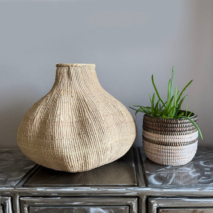 Woven sculptural basket with narrow neck and rounded base, medium-to-large size.