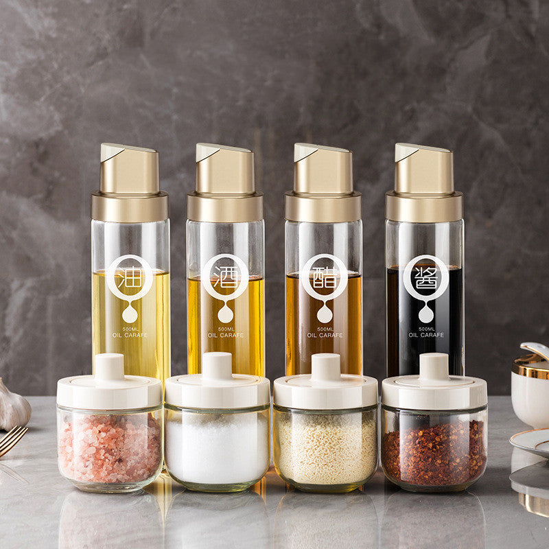 Set of clear glass oil dispenser bottles with gold caps and pump nozzles