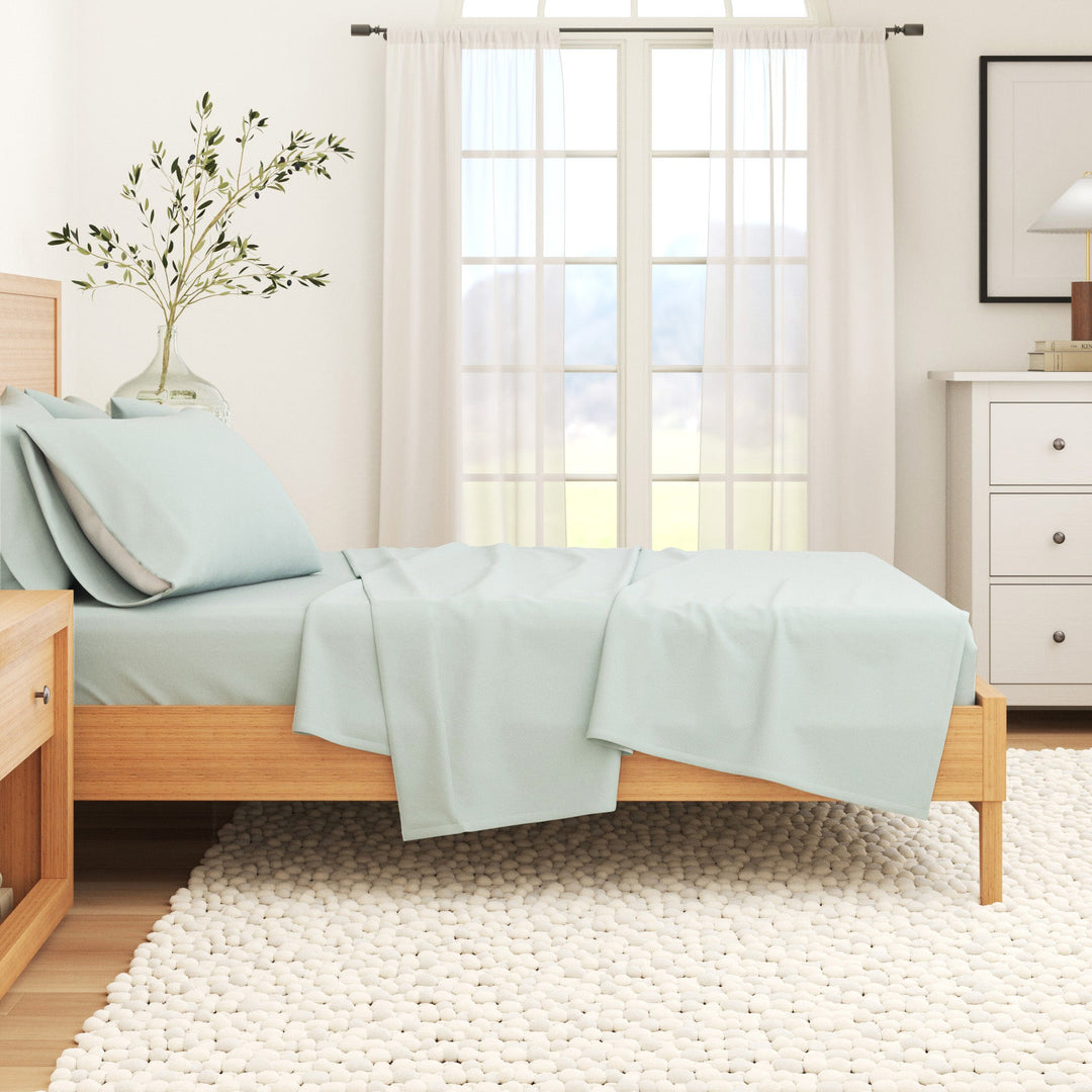Light blue cotton flannel sheet set draped over a bed