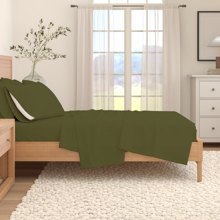 Olive cotton flannel sheet set on a bed with folded flat sheet and pillow