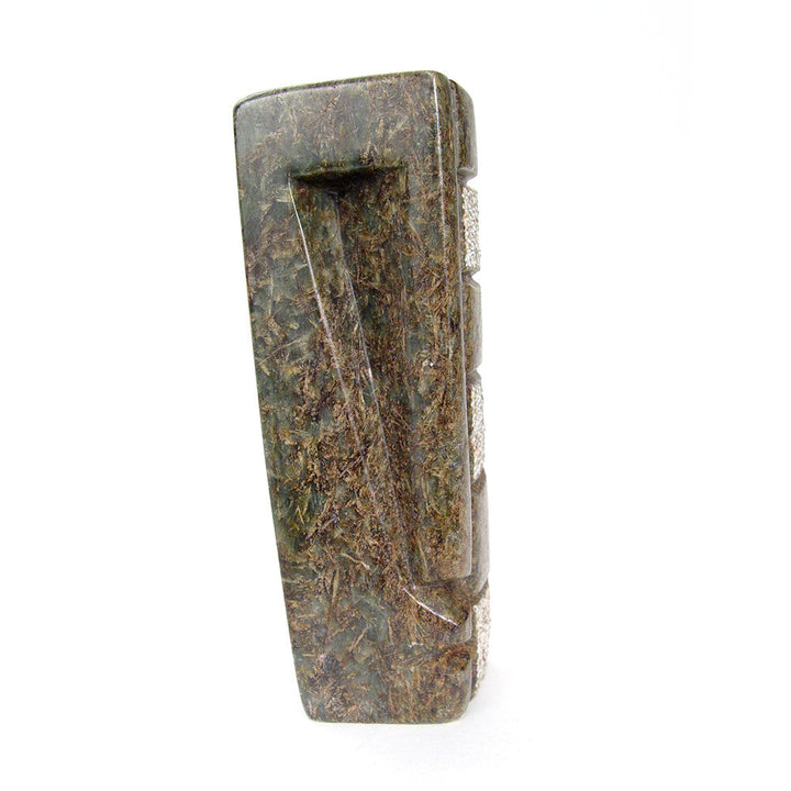 Abstract stone sculpture with textured blue-gray surface and curved white accent blocks