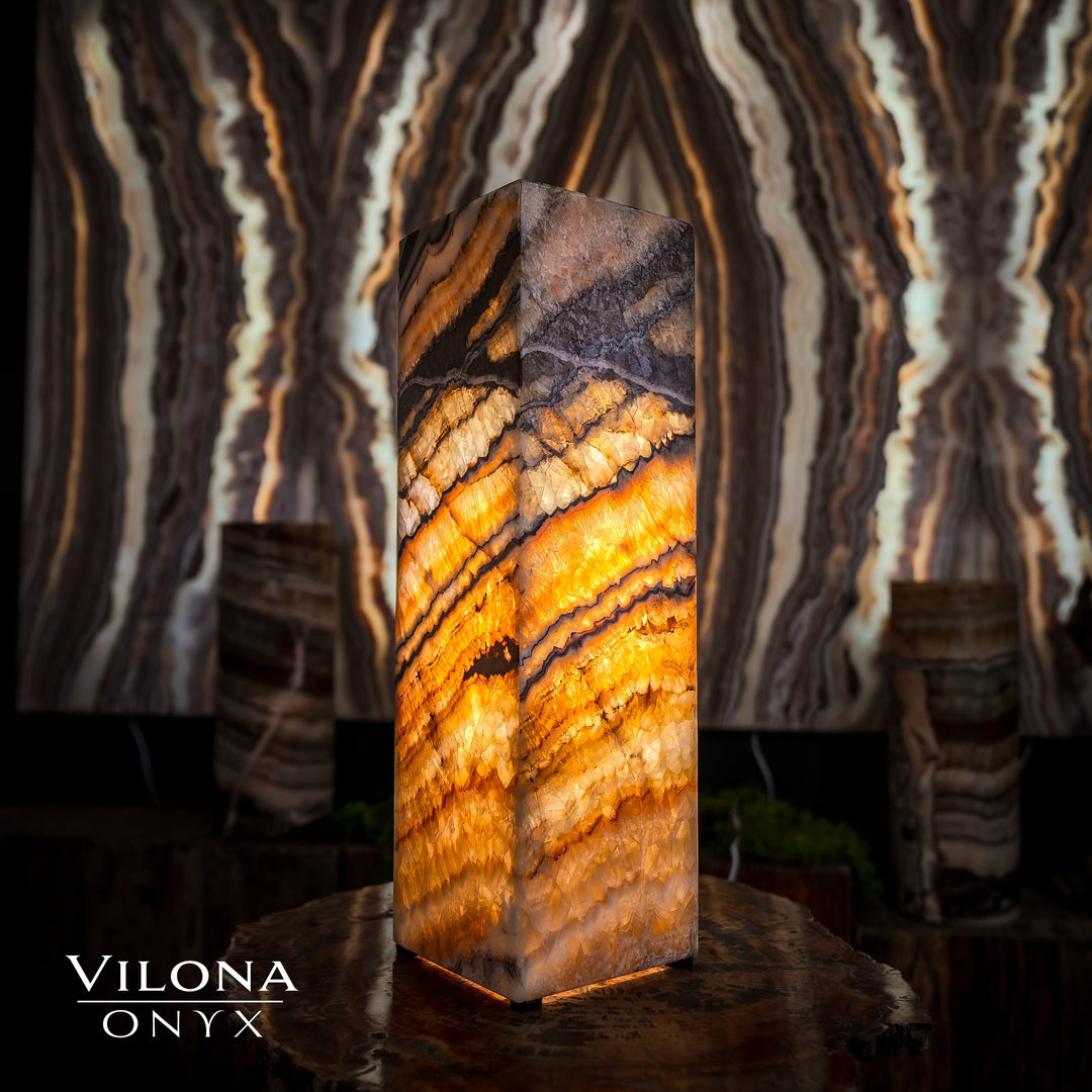 Small square table lamp with warm amber onyx stone body and faceted top edges