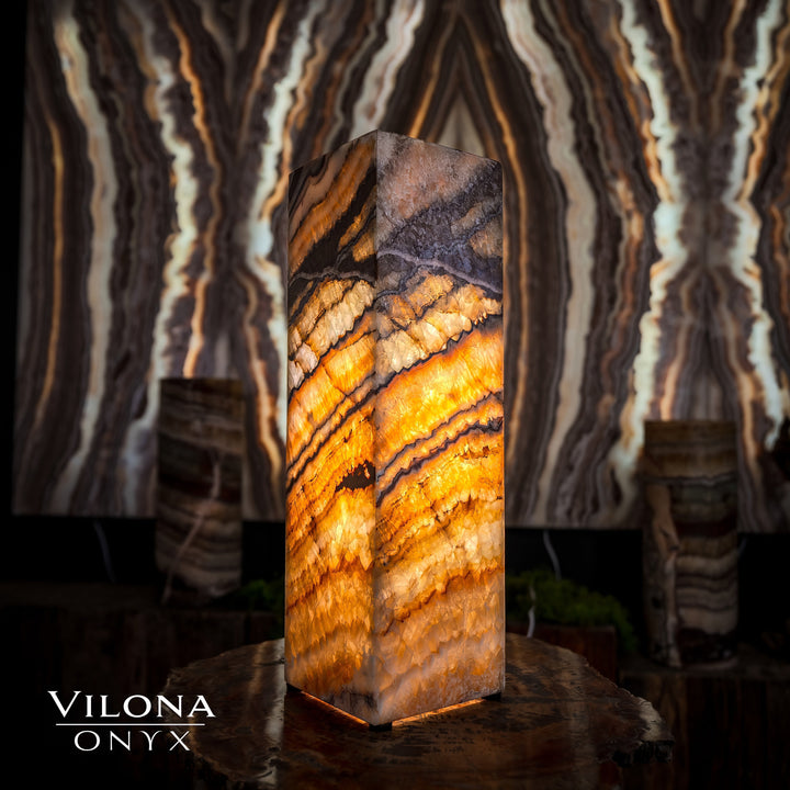 Small square table lamp with warm amber onyx stone body and faceted top edges