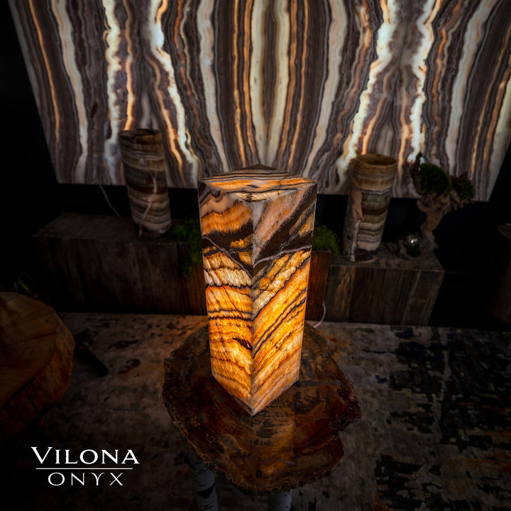 Small square table lamp with amber onyx stone shade on a round rustic side table
