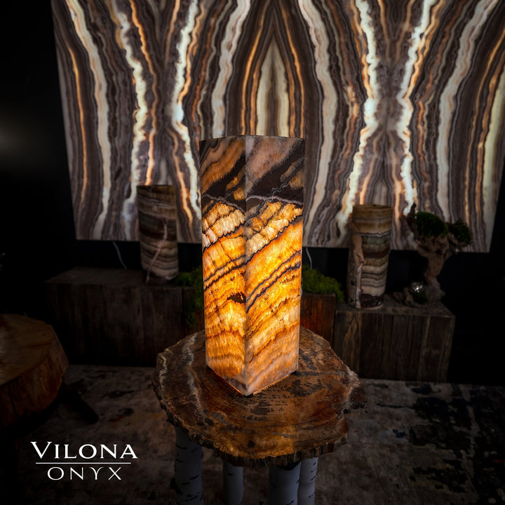 Small square table lamp in amber onyx stone with glowing horizontal banded stripes