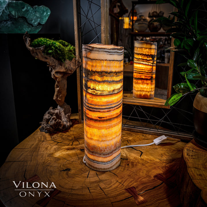 Onyx table lamp with tall cylindrical shade, glowing amber banded onyx finish