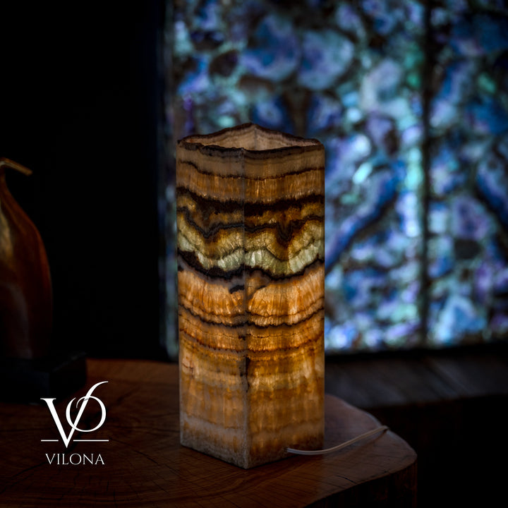 Small table lamp with square live-edge wood base, warm amber wood grain with layered rings