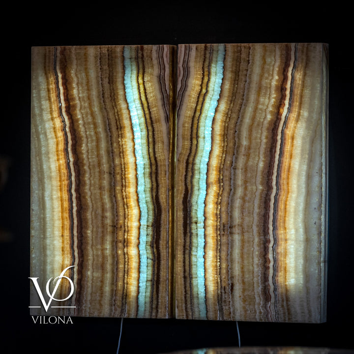 Onyx wall panel with vertical bands of amber, cream, and blue veining