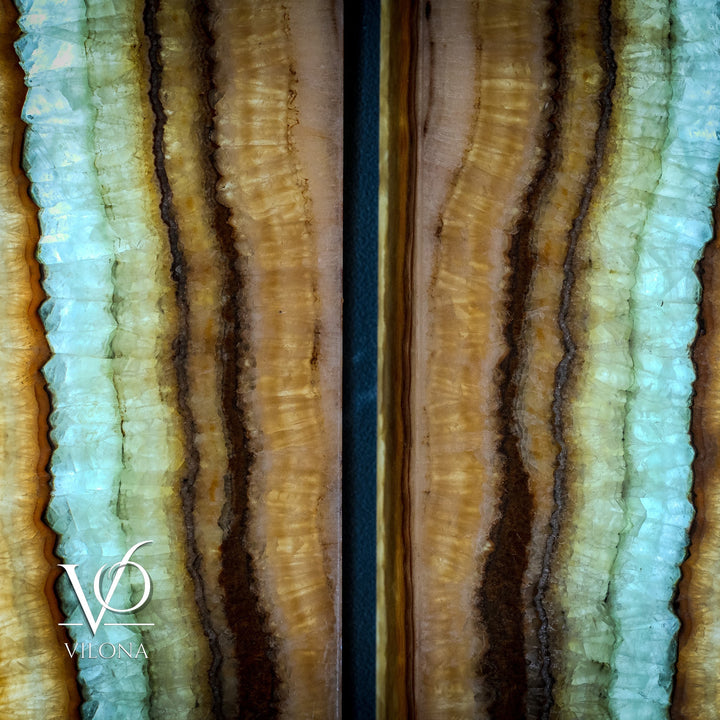 Close-up of two onyx-style wall panels with aqua-green and amber vertical striations