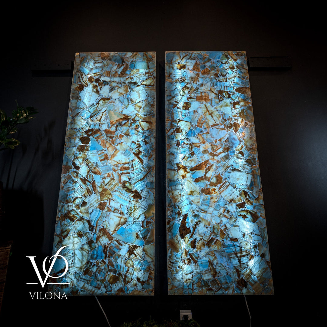 Pair of blue onyx mosaic wall panels with bright backlighting on textured stone