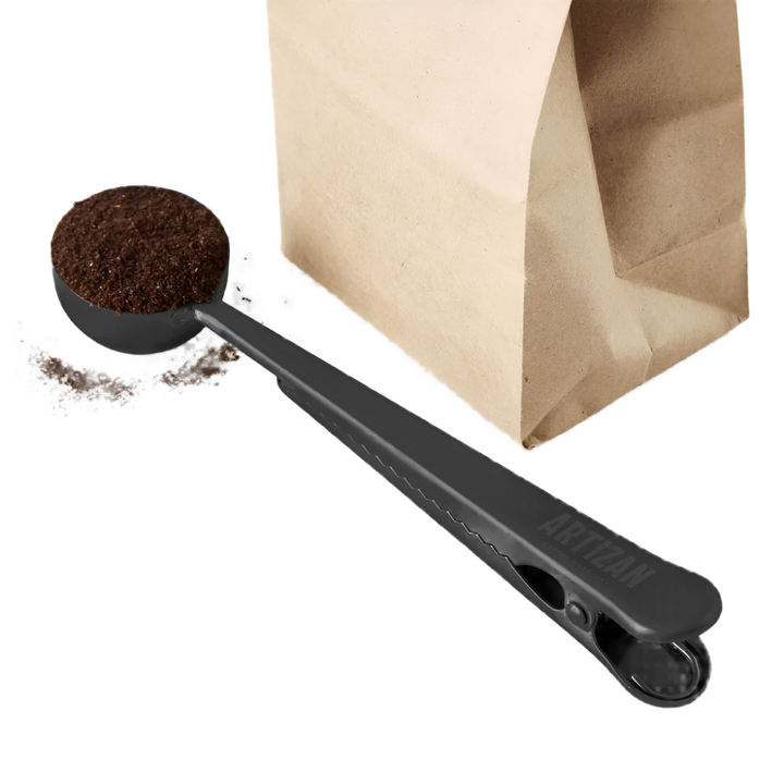 Coffee scoop with bag clip, black scoop next to open kraft paper coffee bag