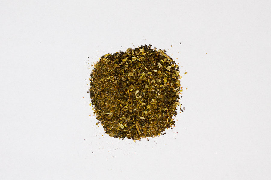 Ground spice rub blend powder mound, speckled green-brown
