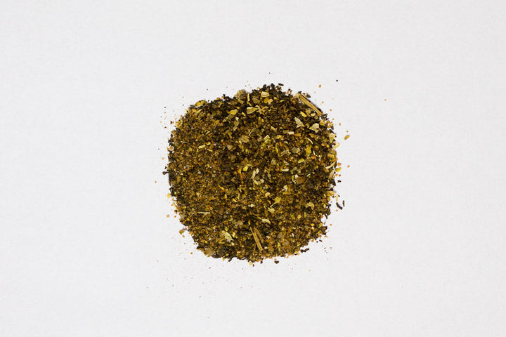 Ground spice rub blend powder mound, speckled green-brown
