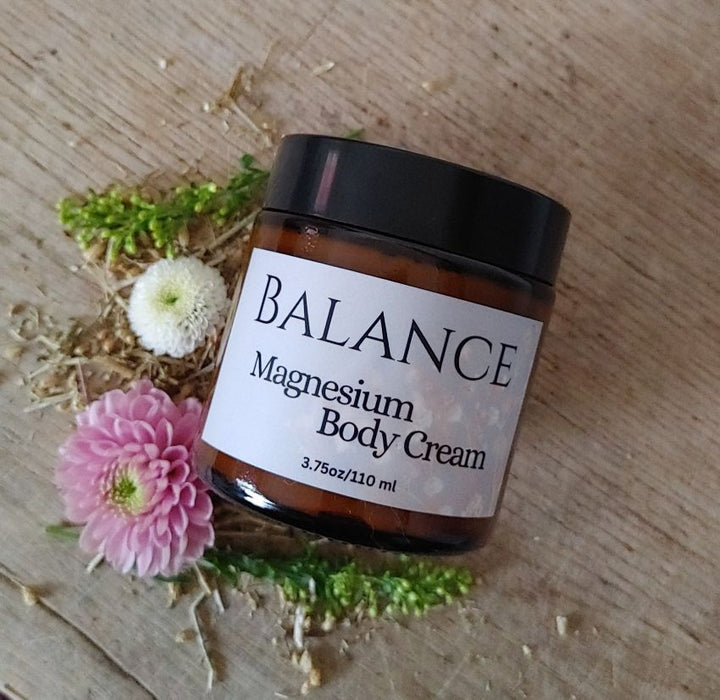 Magnesium body cream jar with BALANCE label, amber container and black lid