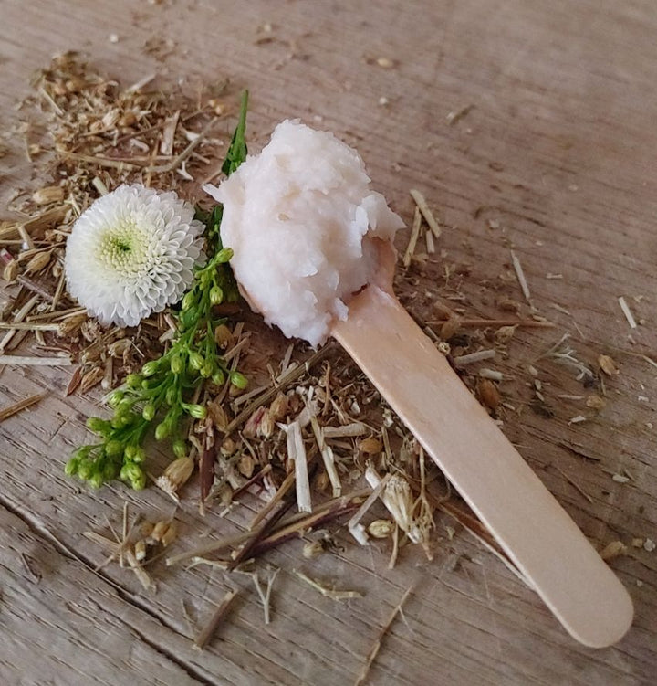 Magnesium body cream with thick white cream on wooden spoon