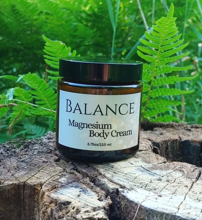 Magnesium body cream jar with BALANCE label, amber container and black lid