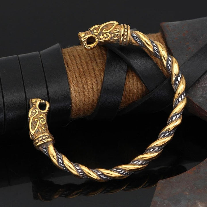 Gold-tone braided stainless steel bracelet with engraved wolf-head end caps