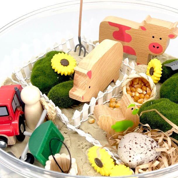 Round clear bowl with farm animal toys and kinetic sand set pieces, incl. pig figure