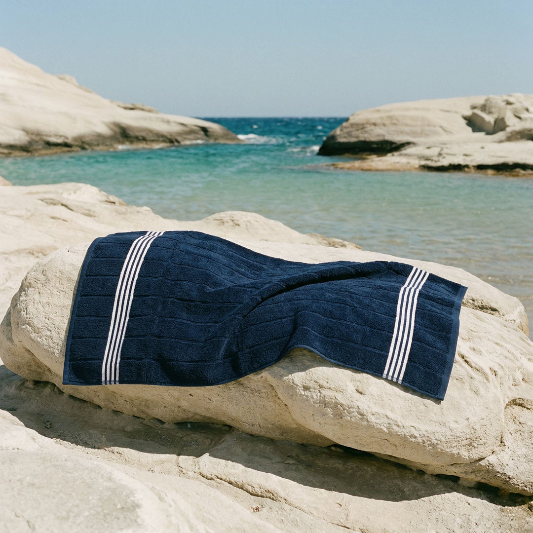 Dark navy cotton towel folded with two white stripe bands