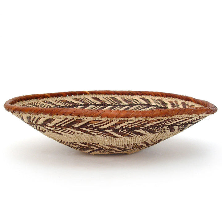 Small woven shallow oval basket with brown rim and geometric dark stripe weave