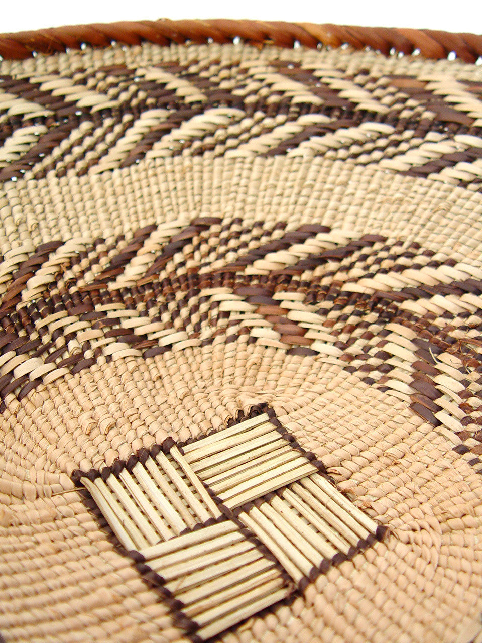 Close-up of woven basket with raised rectangular inlay motif at the center